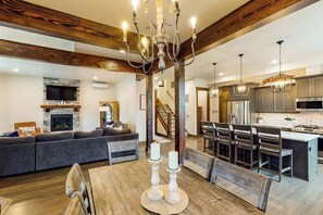 A modern kitchen with a central island, built-in appliances, and a dining area with a wooden table and chairs. - Spacious 4BR Waterview Suncadia Resort (Cle Elum)
