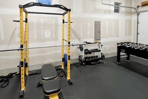 A gym with a squat rack, bench, and dumbbells. - Spacious 4BR Waterview Suncadia Resort (Cle Elum)