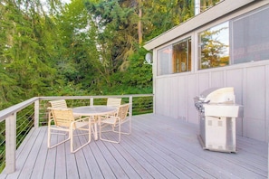 A deck with a grill and outdoor furniture. - 1BR water-view cabin with fireplace (Port Ludlow)