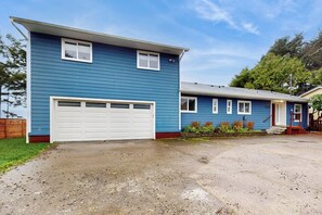 A two-story residential building with a garage and a covered porch. - 5 BD ocean view home with private hot tub (Moclips)