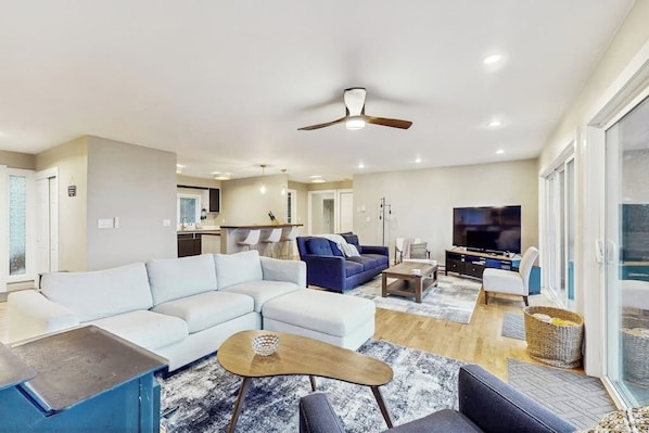 A modern living room with a sectional sofa, a coffee table, and a television.
