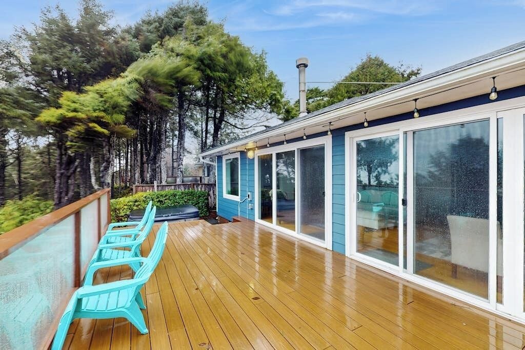 A wooden deck with outdoor seating and a covered area with sliding glass doors.