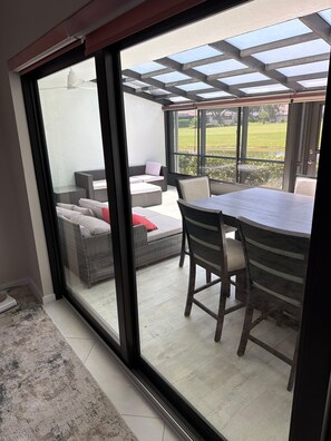 Ein Zimmer mit einer Glasschiebetür, die auf eine Terrasse im Freien führt.