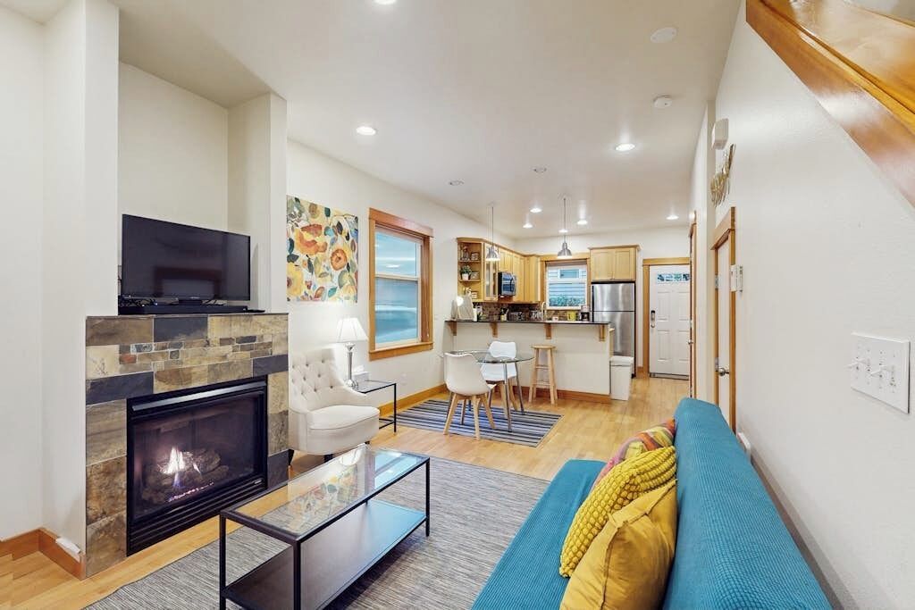 A modern living room with a fireplace, a television, and a sofa.