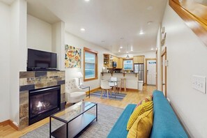 A modern living room with a fireplace, a television, and a sofa. - 2 BR townhome with gas fireplace and backyard (Seattle)