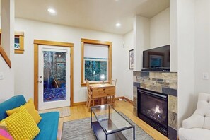 A living room with a fireplace, a sofa, a coffee table, and a dining area with a table and chairs. - 2 BR townhome with gas fireplace and backyard (Seattle)