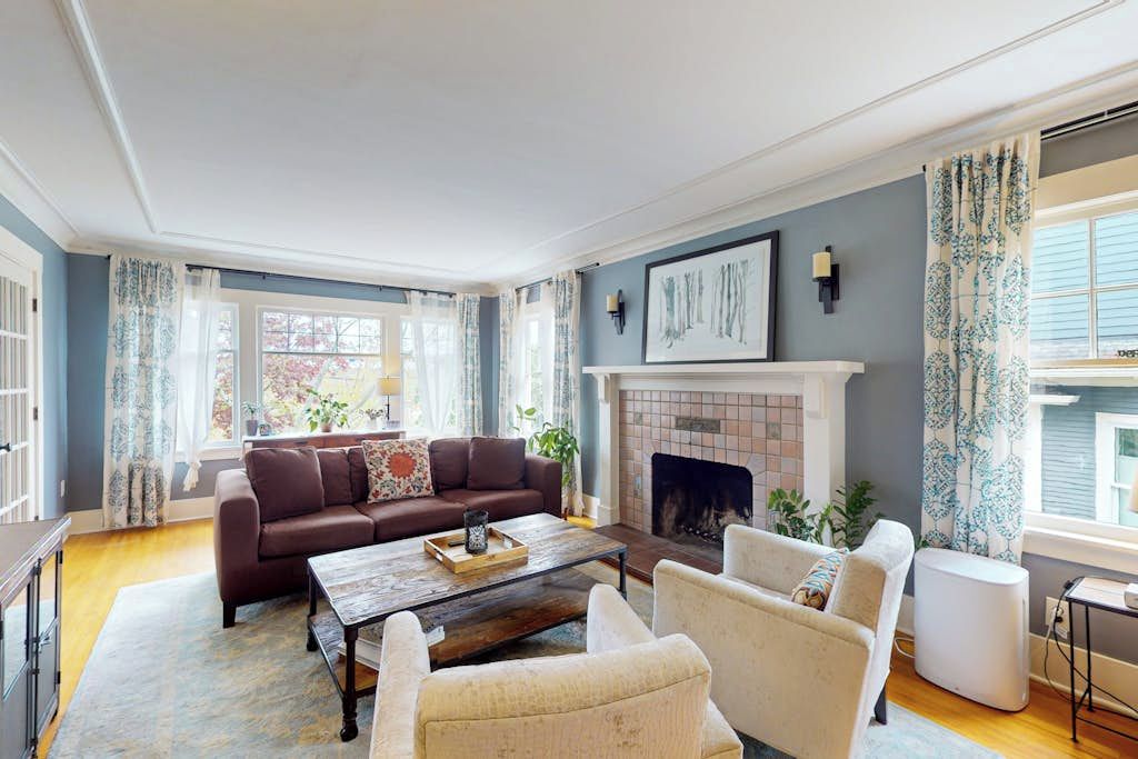 A living room with a fireplace, a sofa, a coffee table, and a fireplace mantel.
