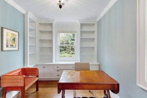 Een eethoek met een houten tafel, een bank en ingebouwde planken.