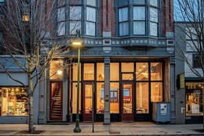 A building with a large glass storefront, a visible staircase, and a street lamp. - Historic Waterfront Hotel & Event Space and Kitchen (Port Townsend)