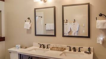 A bathroom with two mirrors, a sink with multiple faucets, and a toilet.