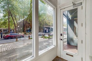 Ein Zimmer mit einem großen Fenster mit Blick auf eine Straße mit Autos und Bäumen.