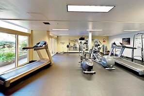 Ein Fitnessstudio mit Laufbändern, Crosstrainern und Kraftgeräten.