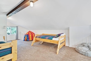 A room with a bunk bed, a play tent, and a bean bag chair.