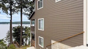 A multi-story building with a balcony, a staircase, and a view of a body of water. - 3BR Bayview | Hot Tub | Deck | Firepit (Port Hadlock)