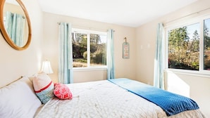 A bedroom with a bed, a window, a mirror, and a wall-mounted sign. - 3BR Bayview | Hot Tub | Deck | Firepit (Port Hadlock)