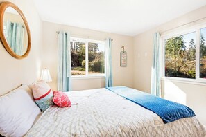 Ein Schlafzimmer mit einem Bett, einem Fenster, einem Spiegel und einem an der Wand befestigten Schild.