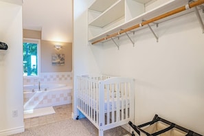 A baby crib in a room with a white wall, a window, and a view of a bathroom with a bathtub. - Stunning 5BR Oceanview Birch Bay Dog Friendly (Blaine)