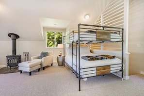 A bunk bed with a heater, a sofa, and a lamp in a room with a sloped ceiling and a window. - Stunning 5BR Oceanview Birch Bay Dog Friendly (Blaine)