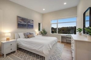 A bedroom with a bed, bedside tables, a desk, and a large window. - 1BR All-New - Central AC - Full Kitchen (Seattle)