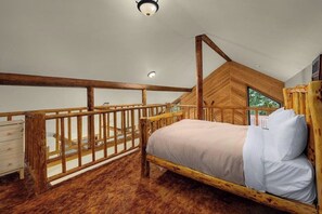 Une chambre avec un lit en bois, une balustrade en bois et une vue sur la verdure.