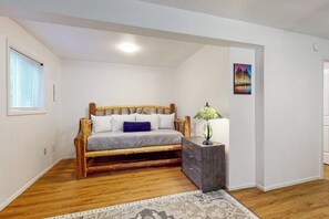 A bedroom with a bed, a nightstand, a lamp, a painting, and a window. - Downtown 3BR Dog Friendly - Fireplace - Washer Dryer (Bellingham)