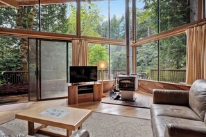 Ein modernes Wohnzimmer mit Fernseher, Holzmöbeln und Kamin.