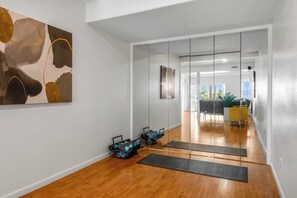 Estúdio de yoga com piso de madeira, bolas de exercício e tapetes.
