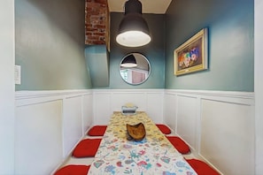 Ein Essbereich mit einem Tisch für zwei Personen, einer Vintage-Schreibmaschine, einem Spiegel und einem gerahmten Bild an der Wand.