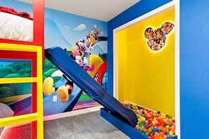 A children's play area with a slide, colorful walls, and a ball pit. - Chic Disney Escape Themed Rooms Private Pool (Davenport)