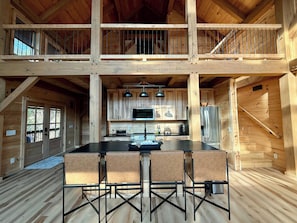 A spacious kitchen with a central island, wooden cabinets, and a stainless steel refrigerator. - Fantastic 4-bedroom, Spacious Timberframe Cabin in charming Lake Lure (Lake Lure)