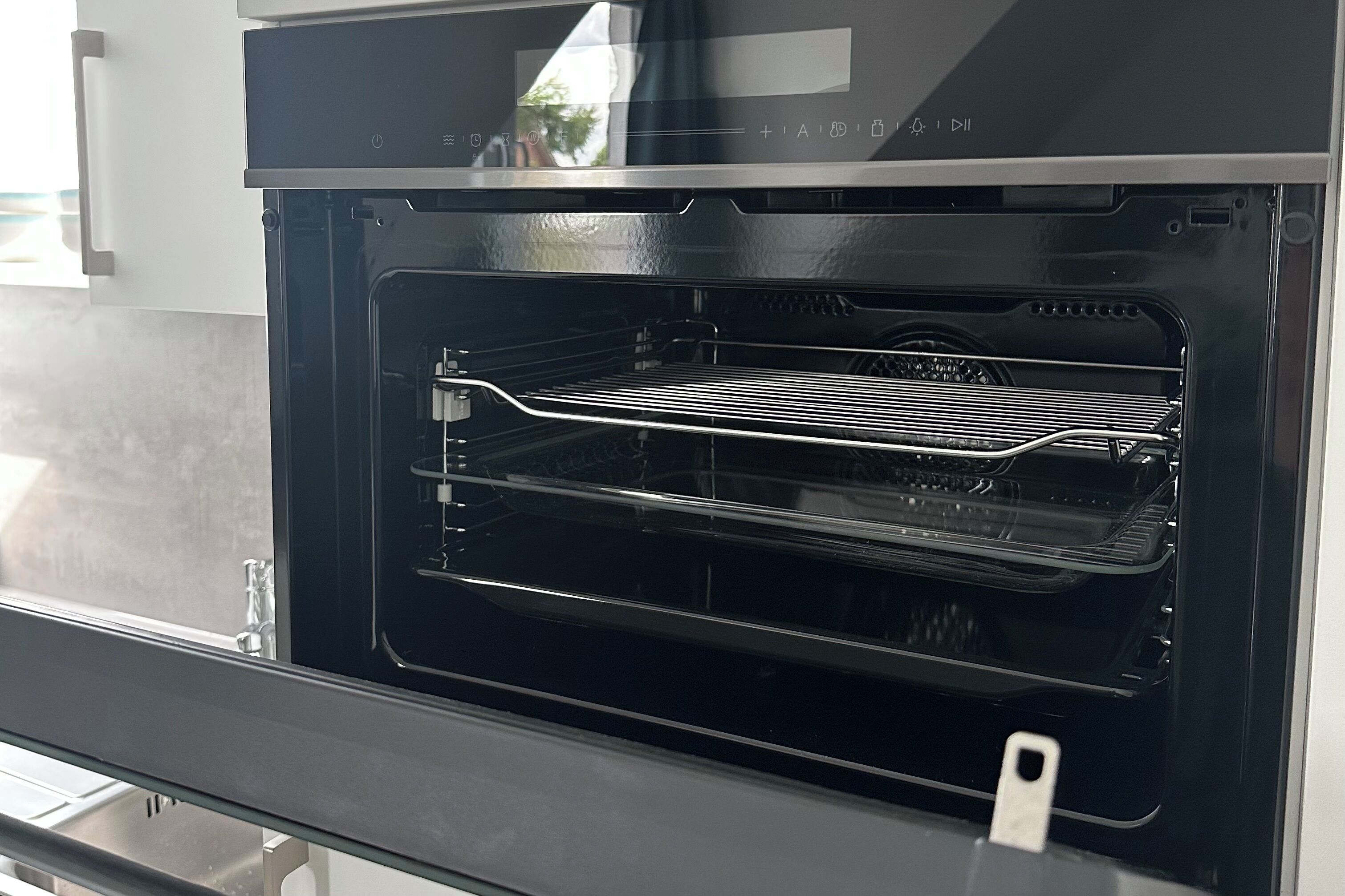 An open oven with a metal rack inside.