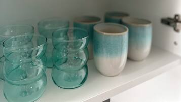 Ein Regal mit verschiedenen Glasbehältern und Keramiktassen.
