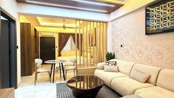 A modern living room with a ceiling fan, a sofa, a coffee table, and a patterned rug.