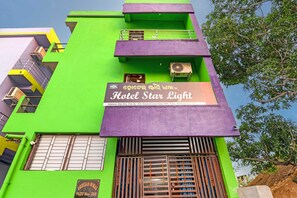 Un edificio de varios pisos con un cartel que dice 'Hotel Star Light' y una unidad de aire acondicionado en el exterior.