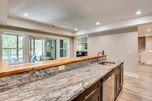 A kitchen with a granite countertop, a built-in dishwasher, and a view of a deck area. - Waterfront Home on Lake Hartwell w/ Dock Access (Hartwell)