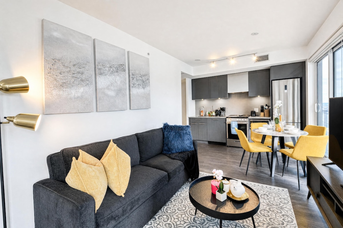 A modern living room with a dark grey sofa, a round coffee table, and a patterned rug.