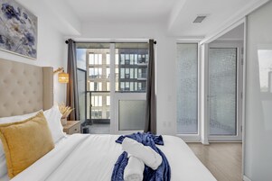 Een hotelkamer met een groot bed, een nachtkastje, een lamp en uitzicht.