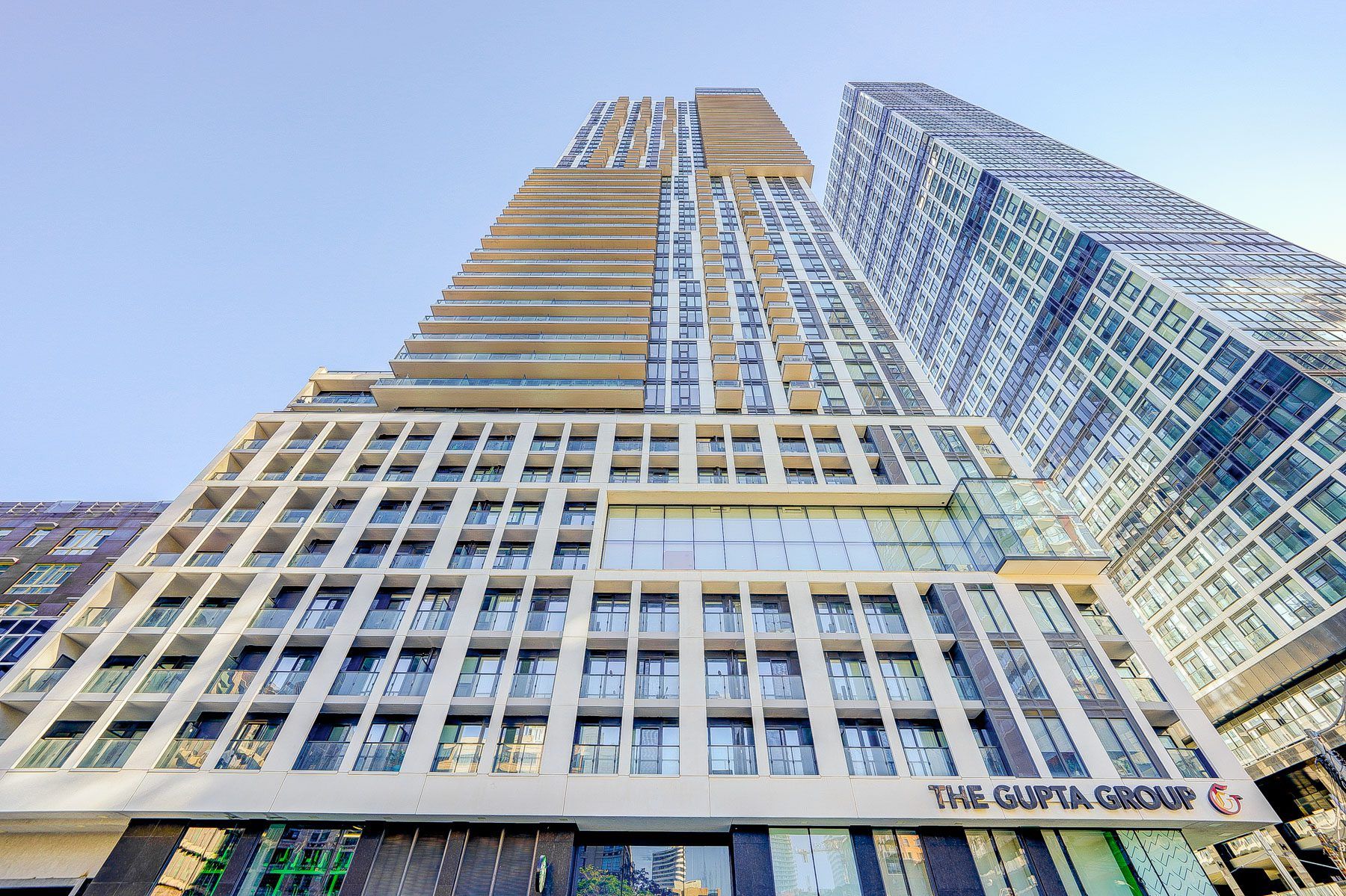 A high-rise building with a prominent sign for 'The Gupta Group' at the base.