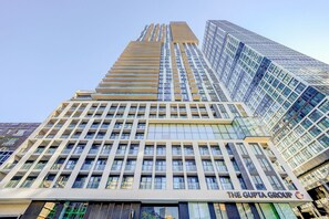 A high-rise building with a prominent sign for 'The Gupta Group' at the base.