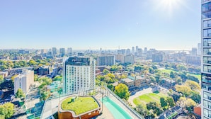 A high-rise building with a rooftop garden and a pedestrian walkway.