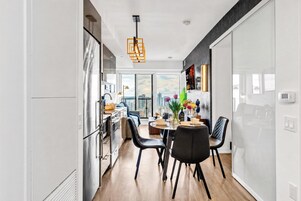 Een moderne keuken met een eethoek, grote ramen en uitzicht over de stad.