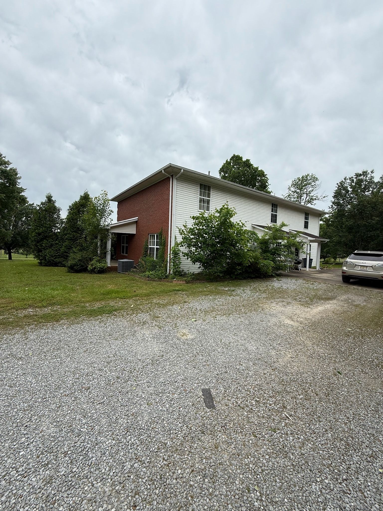 A two-story house with a gravel driveway and a garage.