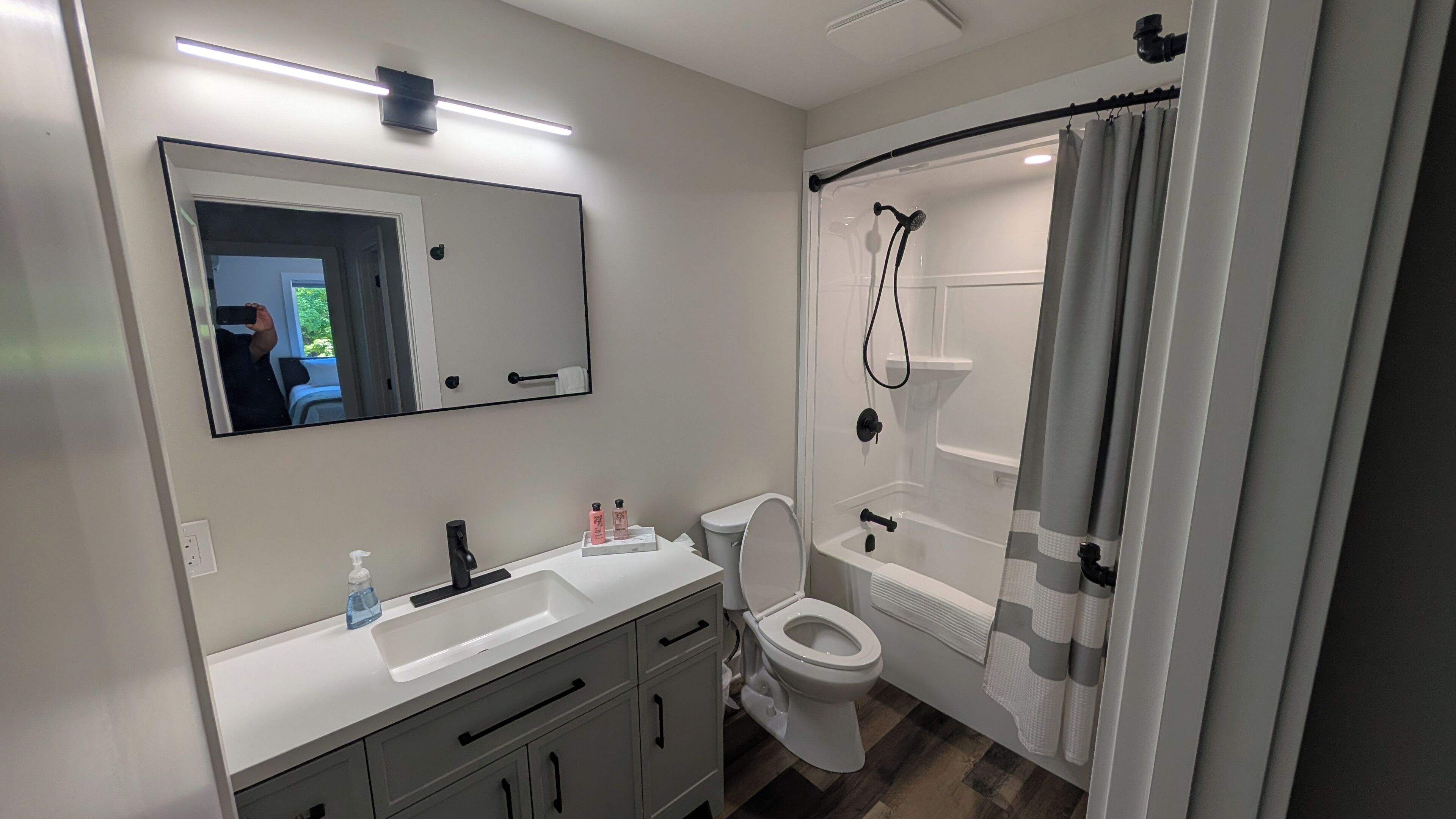 Une salle de bain moderne équipée de toilettes, d’un lavabo et d’un espace douche.