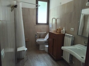 A bathroom with a shower, toilet, and sink.