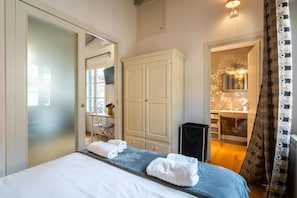 A hotel room with a bed, a wardrobe, a bathroom, and a mirror. - Appartamento di charme (Florence)