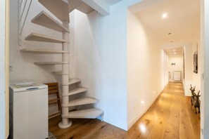 A spiral staircase with a white finish, leading to an upper floor. A white appliance is visible on the lower landing. - Appartamento di charme (Florence)