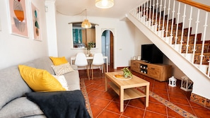A living room with a sofa, a coffee table, and a TV stand. - Playa & Golf Townhouse - 2 min from MAJ Golf Academy (Torremolinos)