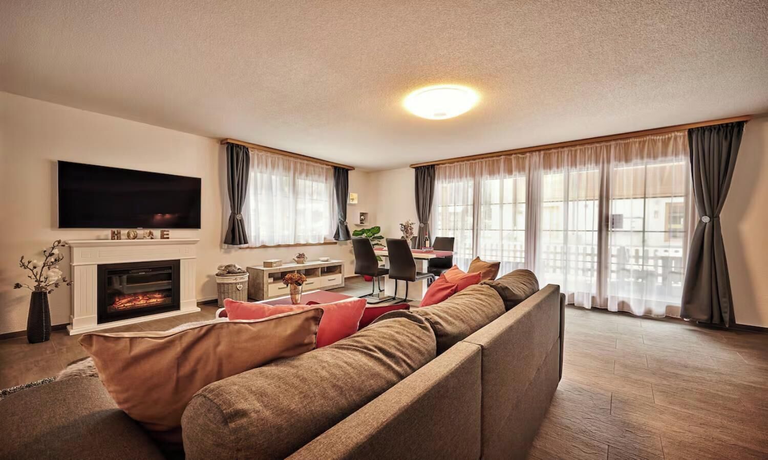 Un salon avec une cheminée, un canapé, un téléviseur et un coin repas.
