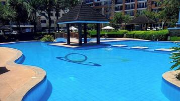 A swimming pool with a gazebo, surrounded by a hotel building.