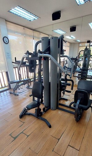 A gym with exercise equipment, wooden flooring, and large windows. - Cebu City Mabolo Resort Style (Cebu City)